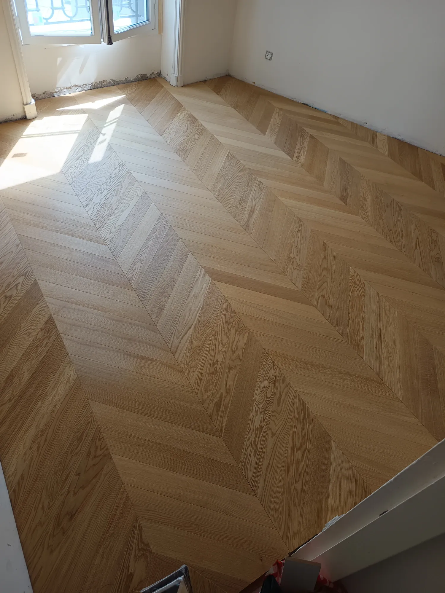 Après pose parquet chevron chêne clair dans une pièce lumineuse — rénovation Mur Sol Yvelines 78
