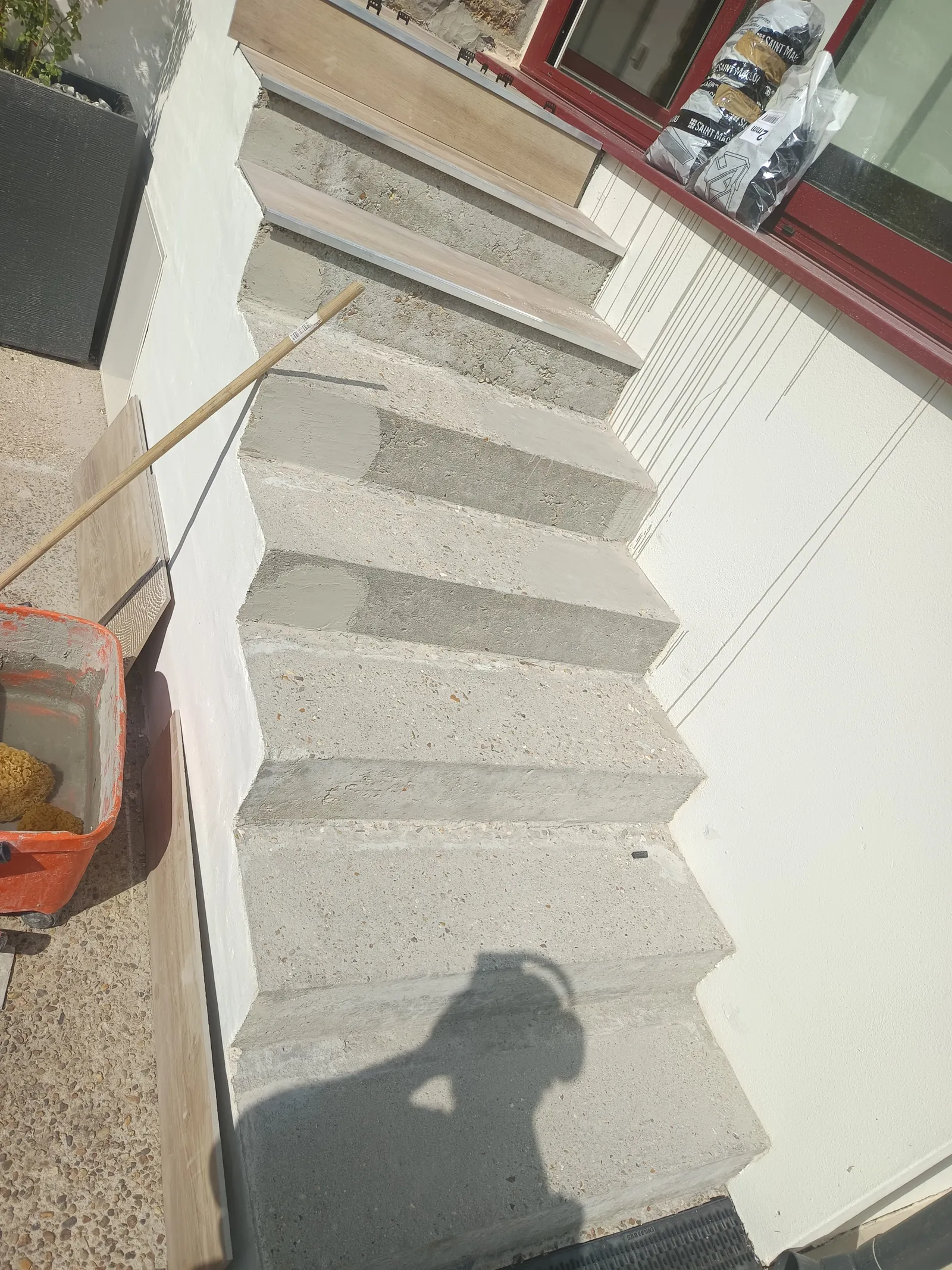 Avant habillage escalier extérieur — marches béton brut avec ragréage en cours, maison Yvelines 78